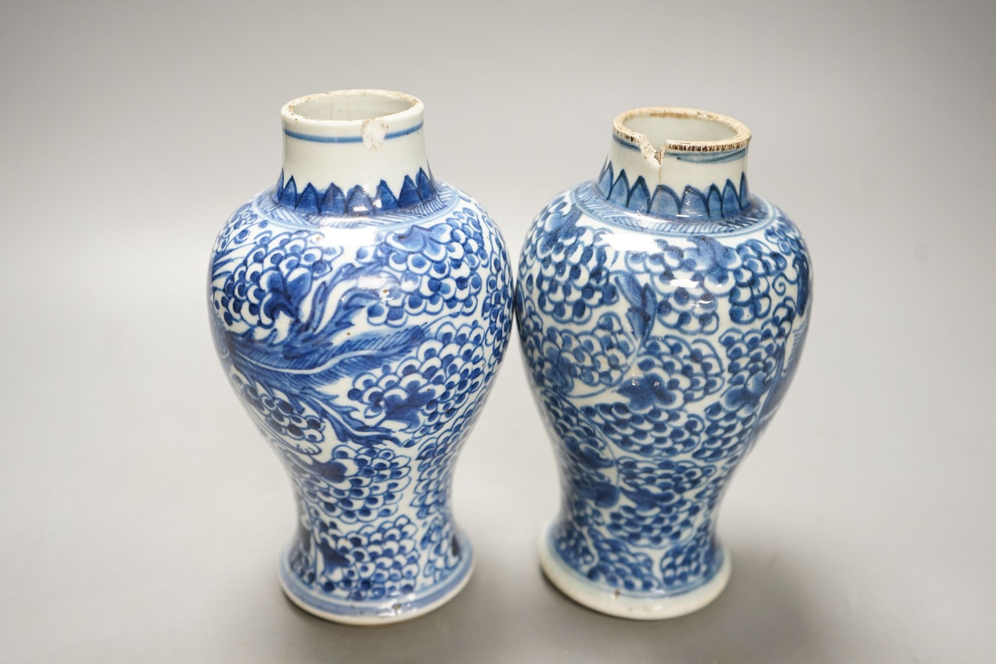 A pair of Chinese blue and white 'phoenix' vases, Kangxi, associated wood covers, 19cm including covers